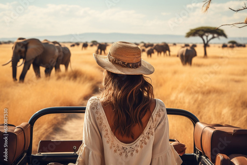 Obraz na plátně woman standing in a safari vehicle tourist elephant in the savanna travel summer