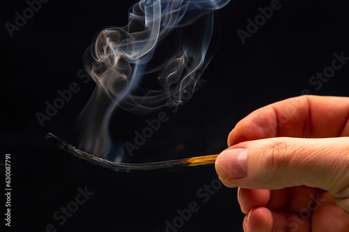 Extinct and fuming wooden match on a dark background close-up. smoke from a burning tree.
