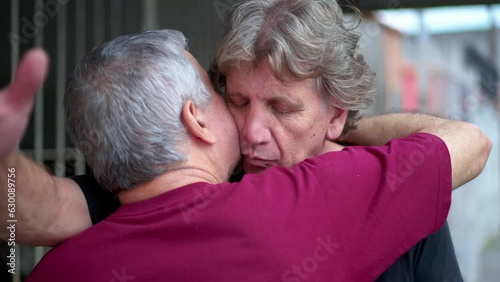 Heart-warming embrace between two senior friends in authentic loving hug. Two elderly people saying farewell embracing, candid and real life family affection