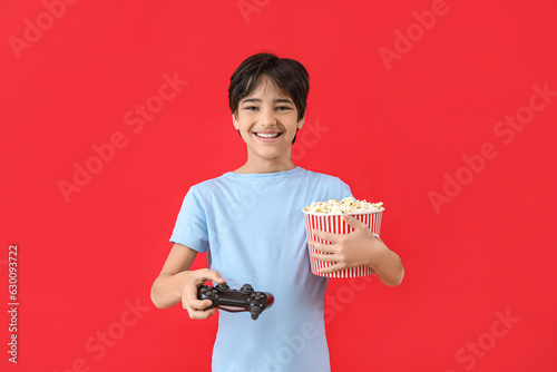 Happy young boy holding vid...
