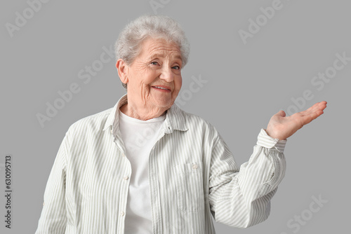 Senior woman showing someth...
