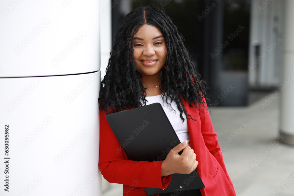 Fototapeta premium portrait of a happy african woman with a black folder in her hands