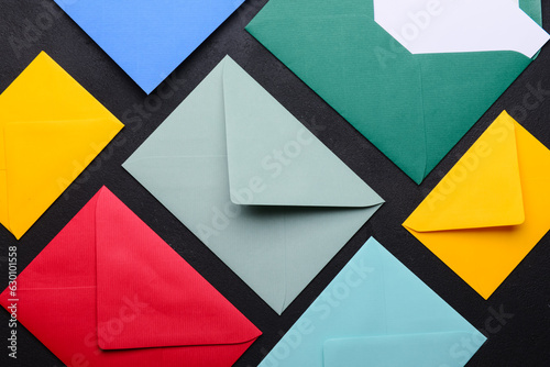 Composition with colorful envelopes on dark background, closeup photo