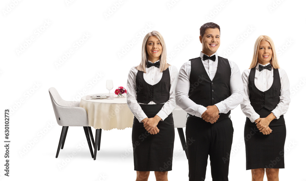 Fototapeta premium Servers in uniforms posing in front of a restaurant table