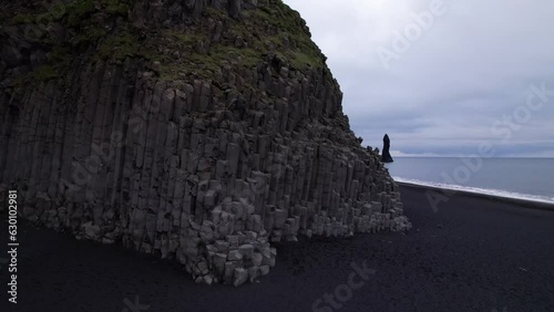 DRONE AERIAL FOOTAGE: Reynisfjara Black sand beach, Halsanefshellir cave, basalt columns and sea stacks at Vik i Myrdal in Iceland. photo