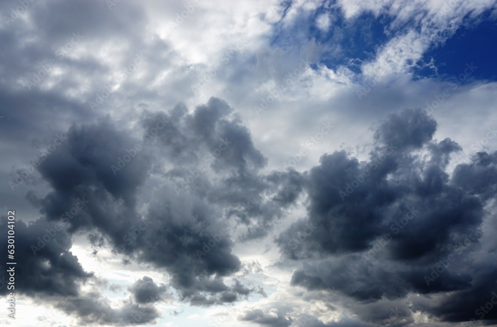 Himmellandschaft mit dramatischem grau-weißen Wolkengebilde bei Sturm, Sonne und Regen im Herbst