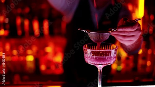 Barman making a cocktail with white sparkling wine at the bar at night with red neon lights, slow motion
