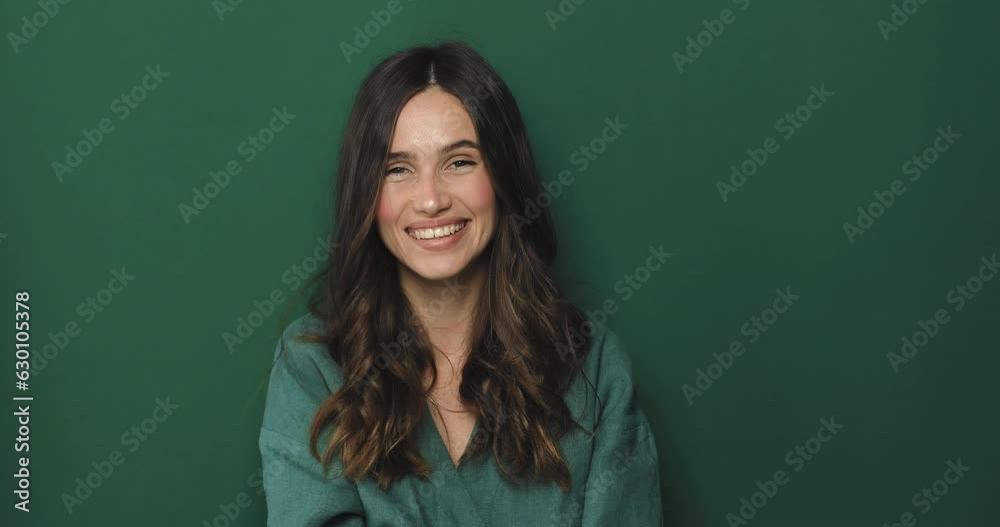 Hey you, come to me. Beautiful young brunette woman with curly hair hold hand near mouth and shout hey you, wear green dress posing isolated on a green background in the studio. Hey you, come to me. Beautiful young brunette woman with curly hair hold hand near mouth and shout hey you, wear green dress posing isolated on a green background in the studio.