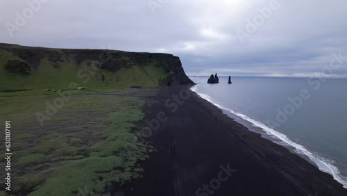 DRONE AERIAL FOOTAGE: Reynisfjara Black sand beach, Halsanefshellir cave, basalt columns and sea stacks at Vik i Myrdal in Iceland. photo