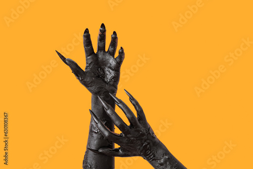 Slika na platnu Black hands of witch on orange background. Halloween celebration