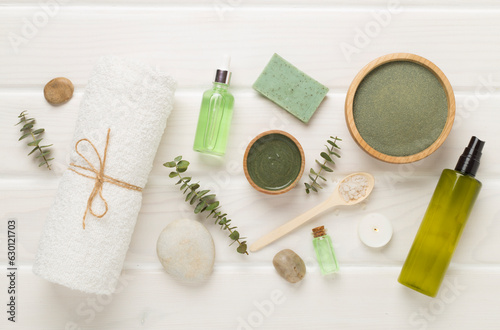 Composition with cosmetic clay and spa products on wooden background, top view