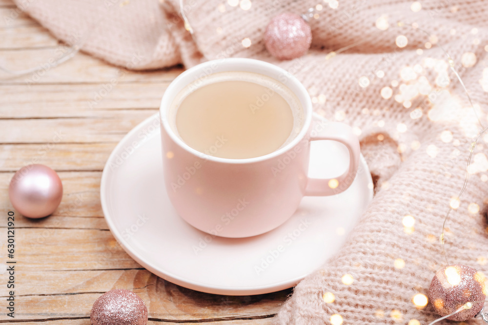A cup of hot drink and Christmas balls on a knitted sweater. Winter holidays concept. Top view A cup of hot drink and Christmas balls on a knitted sweater. Winter holidays concept. Top view