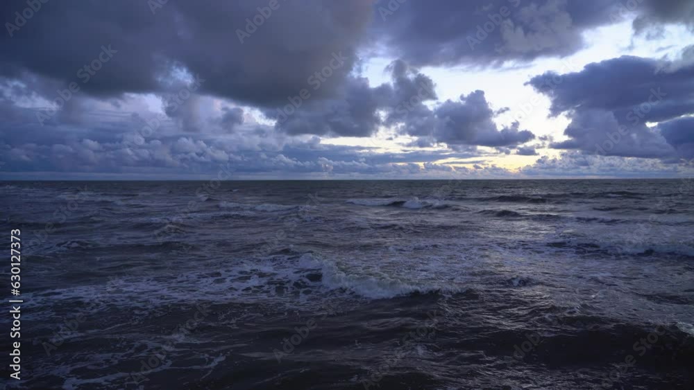 Powerful strong waves are moving across the sea against the background of a stormy sky Powerful strong waves are moving across the sea against the background of a stormy sky