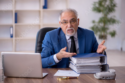 Old male employee working in the office