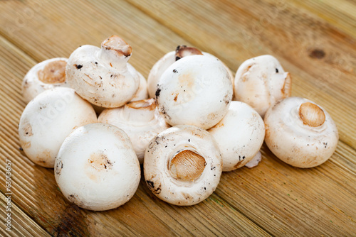 Fresh champignon mushrooms on wooden background