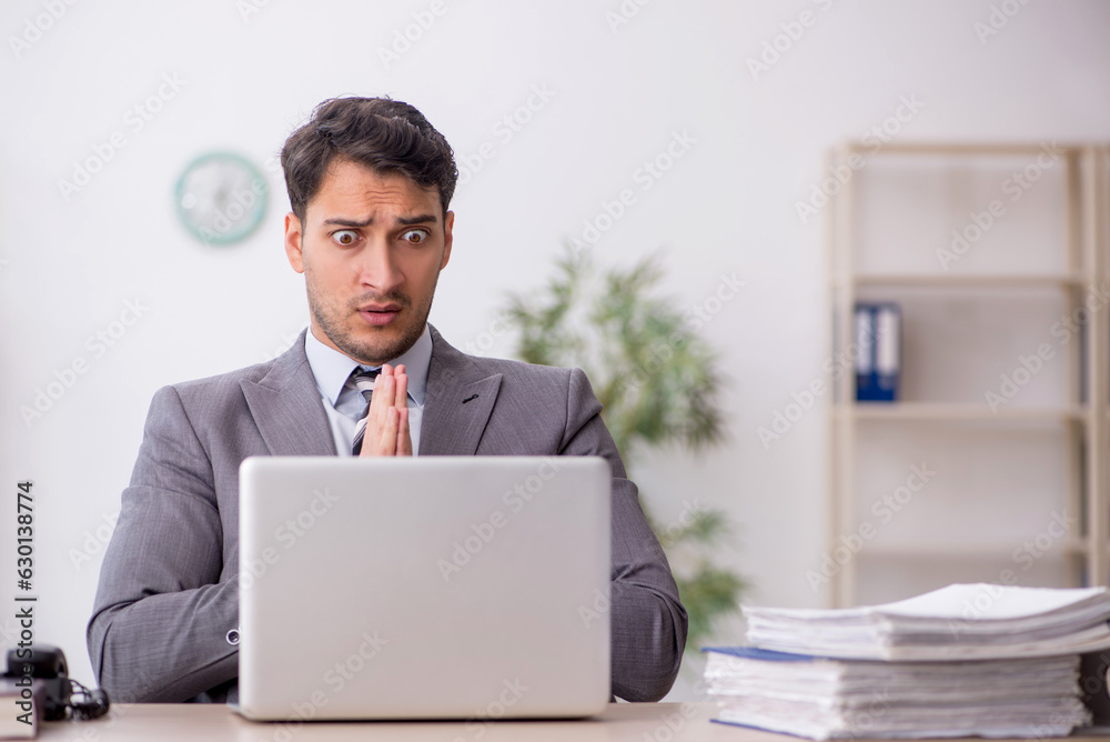 Young male employee working in the office Young male employee working in the office