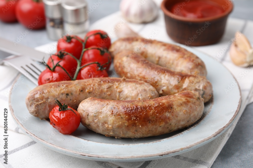 Plate with tasty homemade sausages and tomatoes on table, closeup Plate with tasty homemade sausages and tomatoes on table, closeup