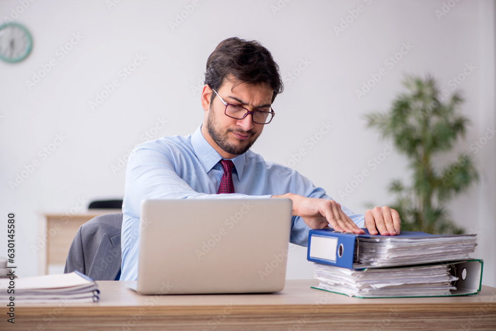 Young male employee sitting in the office Young male employee sitting in the office