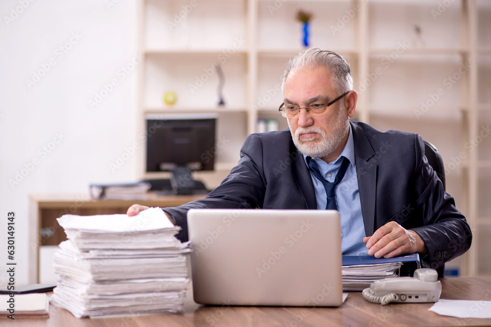 Fototapeta premium Old male employee and too much work in the office