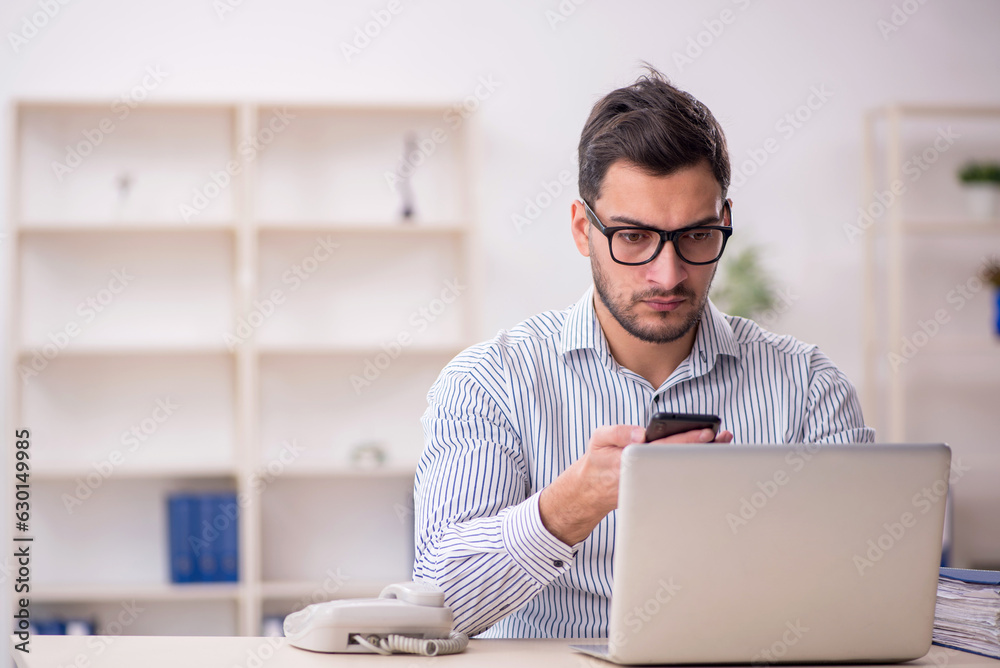 Young male employee working in the office Young male employee working in the office