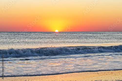 Tableau sur toile A lone bird tries to get to the sun at the horizon - Outer banks, NC, USA