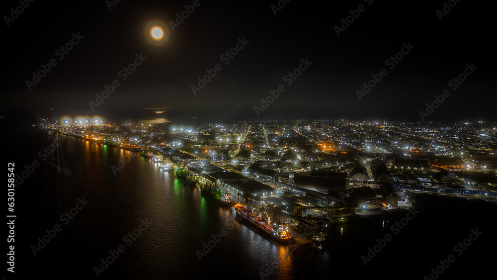 Night aerial view of Porto de Paranaguá with part of the city and the full moon in the sky, Paranaguá, Paraná, Brazil.