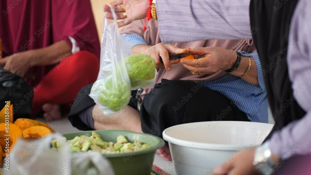 An elderly Indonesian woman's hands cut a pumpkin during a communal cooking event in Tarakan, Indonesia An elderly Indonesian woman's hands cut a pumpkin during a communal cooking event in Tarakan, Indonesia