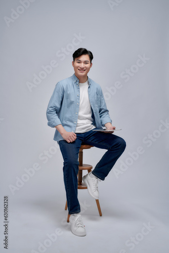 Image of young Asian man sitting on chair