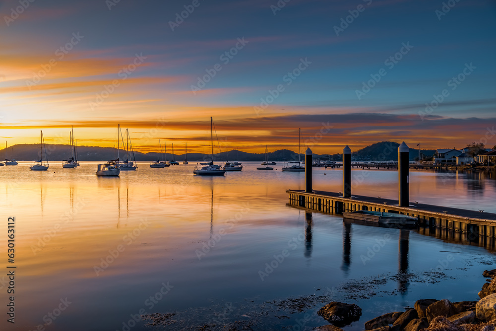 Sunrise at the jetty with high cloud and boats on the water