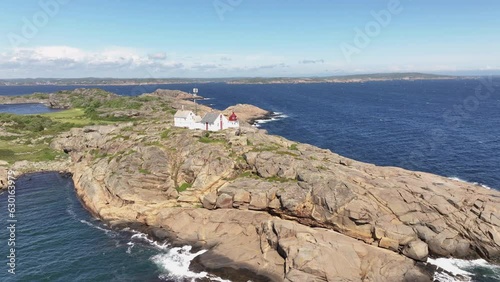 Daytime Landscape Of Stavernsodden Lighthouse On A Rocky Coast In The Island Of Stavern, Norway. aerial, pan shot photo