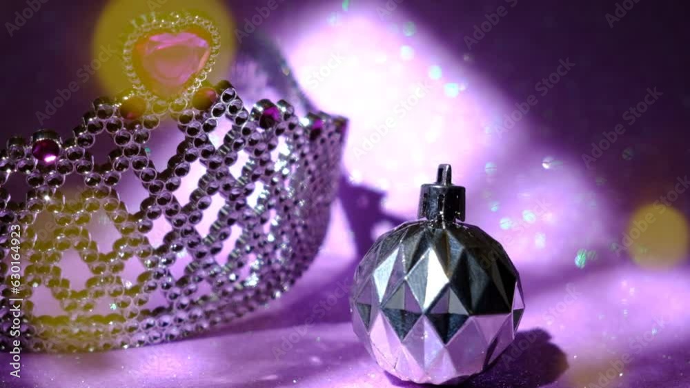 Christmas tree toy ball  decorations and crown, lilac light. Luxury  silver purple black backdrop. Glittering abstract flares bokeh background. Happy New Year and Merry Christmas