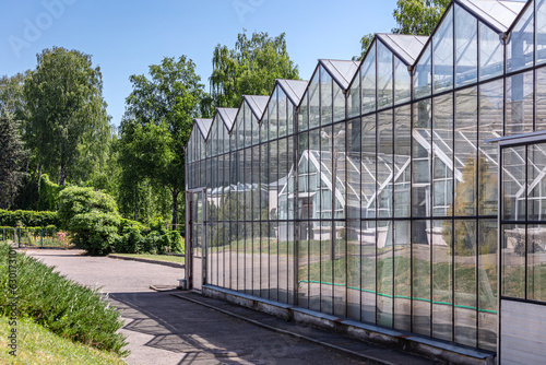 greenhouse in the botanical garden on sunny summer day in an environment of green trees
