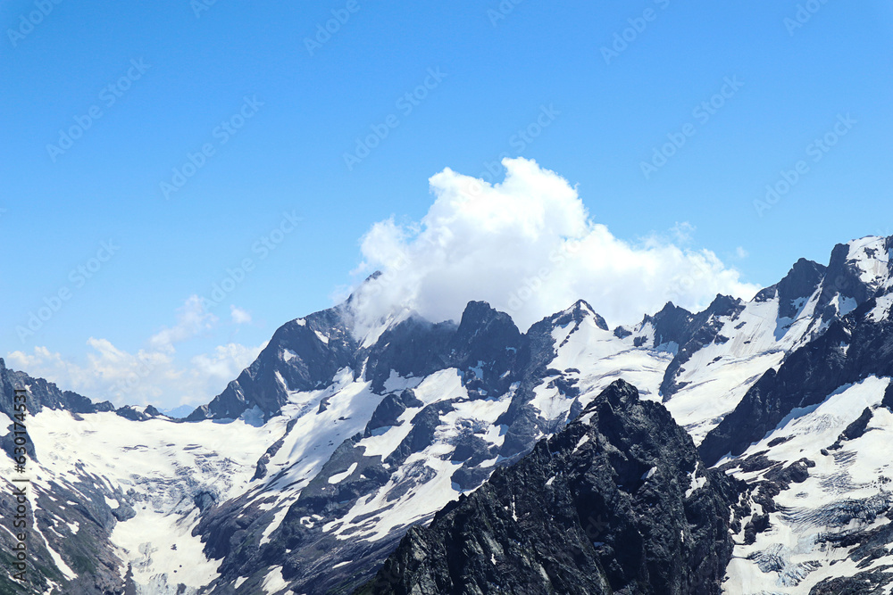 Obraz premium Mountain landscape: white weightless clouds among the mountains on a summer sunny day, close-up