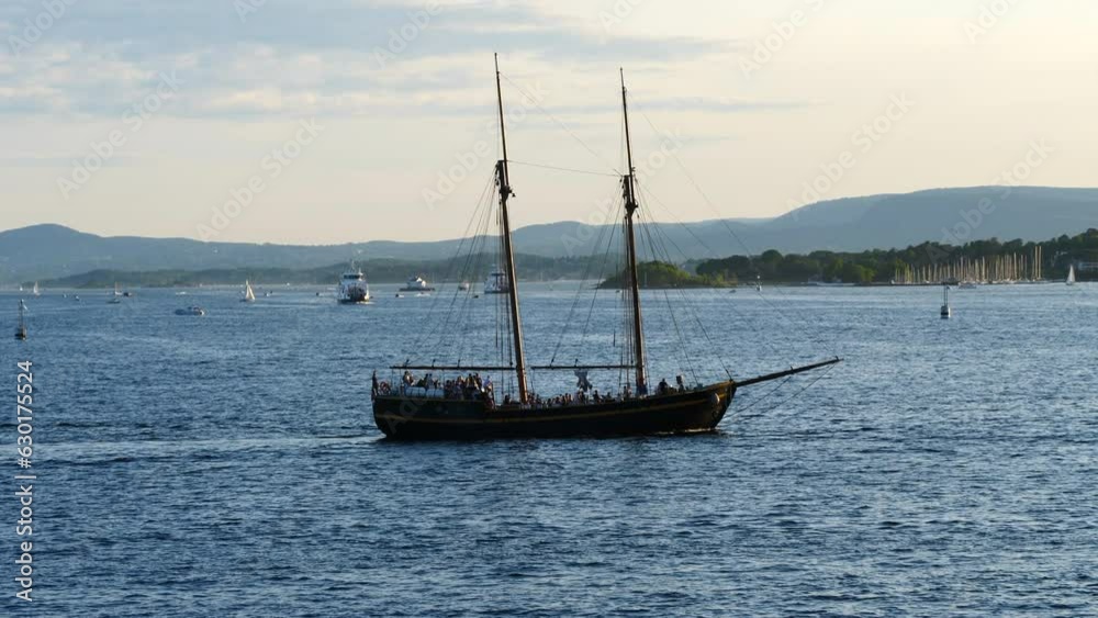 Sailboat with Tourists Cruising in the Oslo Fjords - Golden Hour Sailboat with Tourists Cruising in the Oslo Fjords - Golden Hour