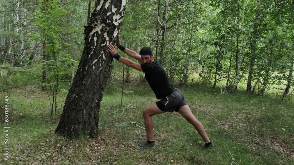 healthy lifestyle.A man in sports gear does a warm-up by running in the woods.Slow motion.Playing sports in nature