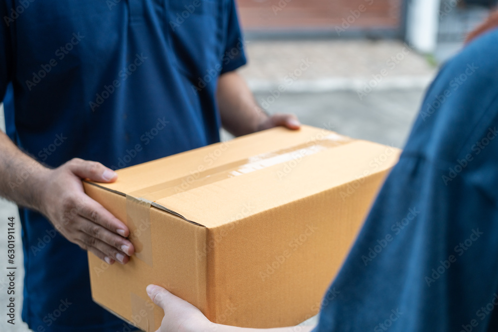 Delivery man holding cardboard boxes. Hand female accepting a delivery boxes of paper containers from courier at home. Signing to get package. Delivery concept. Delivery man holding cardboard boxes. Hand female accepting a delivery boxes of paper containers from courier at home. Signing to get package. Delivery concept.