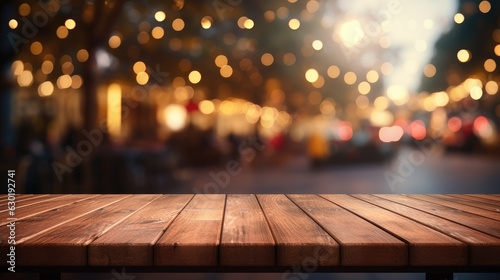 Empty brown wooden tables and bokeh lights blurred outdoor cafe abstract background of restaurant lighting where people enjoy eating can be used for montages or to display your products.