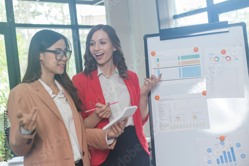 Two brunette business woman, talking, advising each other.