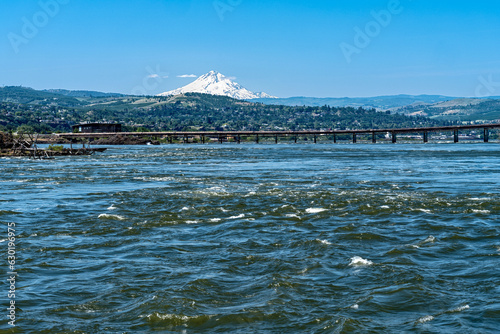 The Dalles Bridge crosses the Columbia River between Oregon and Washington with Mount Hood rising behind it photo