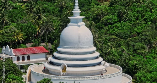 Unawatuna Sri Lanka Aerial v11 close up drone flyover and around Japanese Peace Pagoda on the Rumassala hill hidden amongst the trees of the rainforests - Shot with Mavic 3 Cine - April 2023 photo