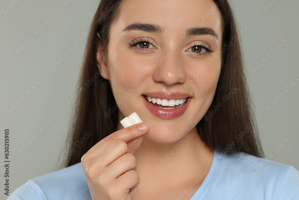 Happy young woman with bubble gums on grey background Happy young woman with bubble gums on grey background