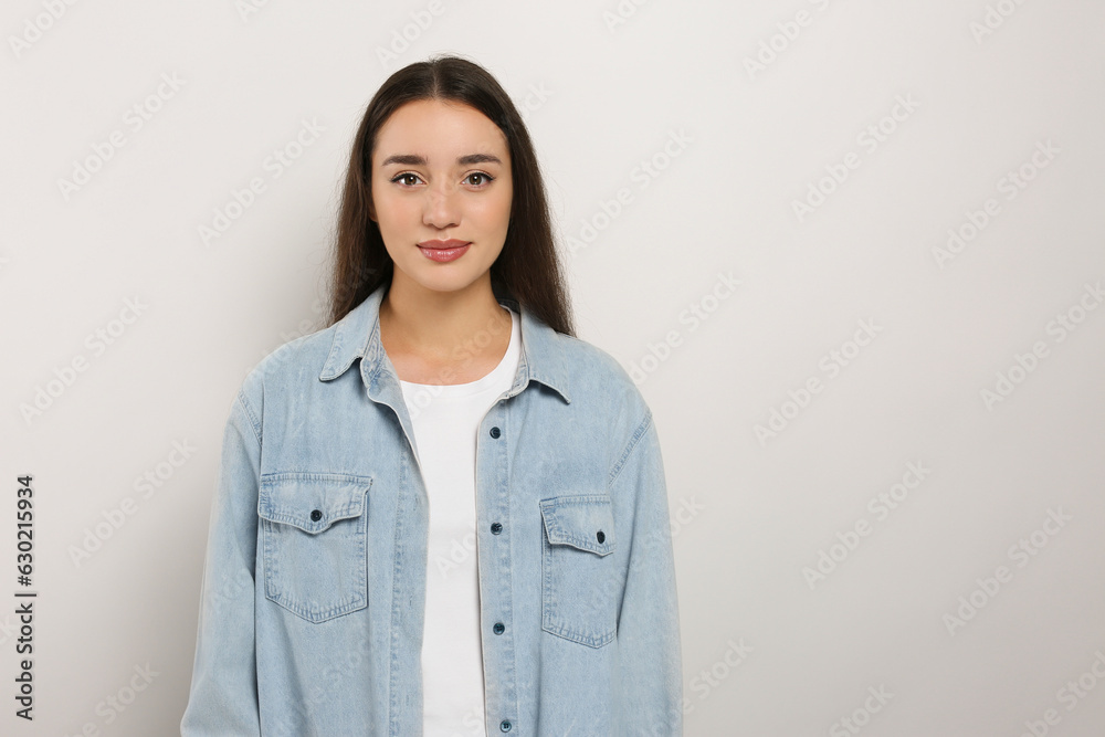 Portrait of beautiful young woman in jeans jacket on white background. Space for text Portrait of beautiful young woman in jeans jacket on white background. Space for text