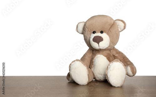 Cute teddy bear on wooden table against white background
