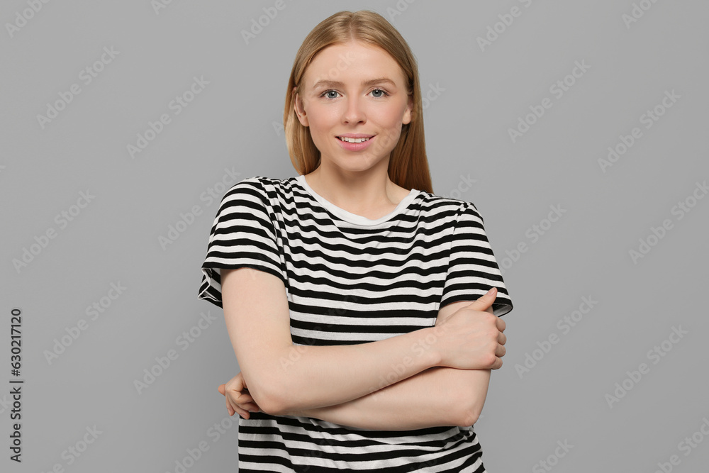 Portrait of beautiful young woman in striped t-shirt on grey background Portrait of beautiful young woman in striped t-shirt on grey background