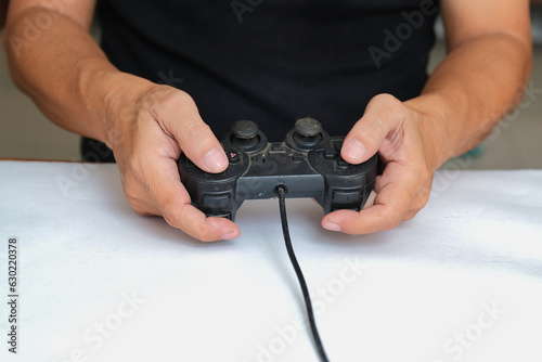 Close-up photo of hands holding black computer game joypad