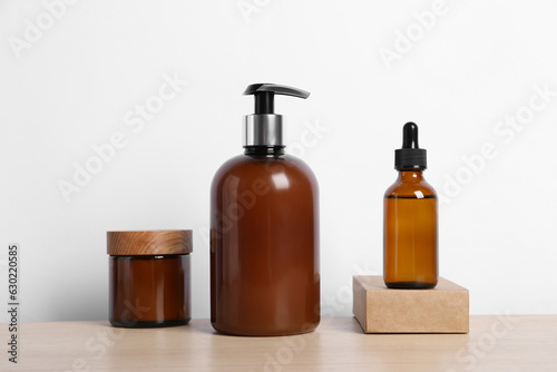 Bottles with different cosmetic products on wooden table