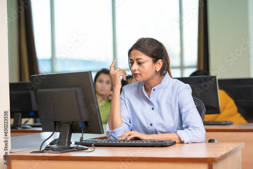 Indian woman working on computer at office.