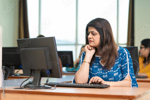 Indian woman working on computer at office. © PRASANNAPIX