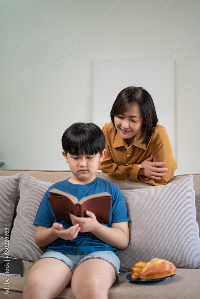 Happy family mom and son reading a book on holiday Happy family mom and son reading a book on holiday