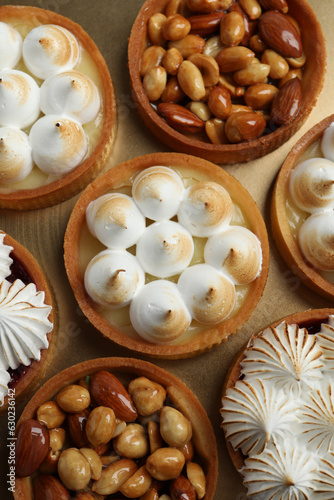 Many different tartlets on golden tray, top view. Delicious dessert